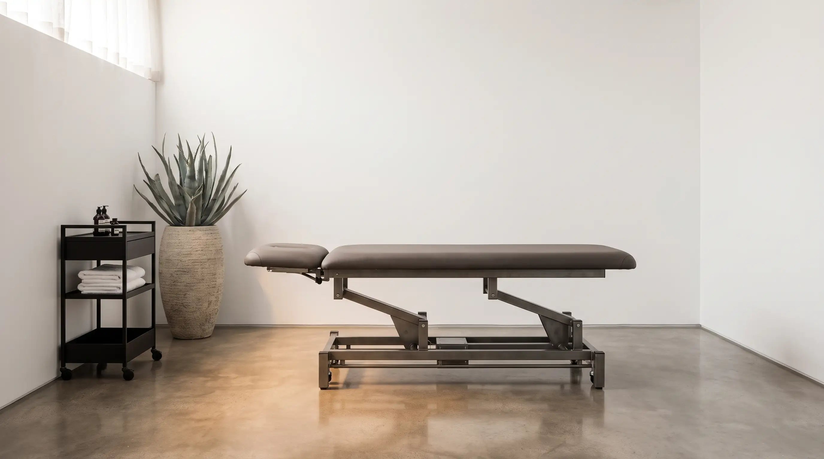 Table de massage à structure acier dans un cabinet professionnel moderne, sélection Le Bon Massage